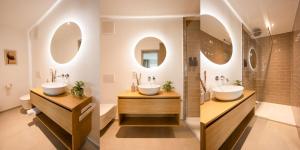 two sinks in a bathroom with two mirrors at DWELLSTAY - City Apartments Fulda in Fulda