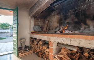 einen großen gemauerten Kamin mit einem Holzhaufen in der Unterkunft 2 Bedroom Nice Home In Nevest in Unešić