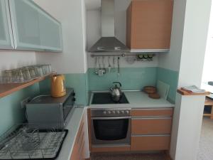 a small kitchen with a stove and a sink at APARTMAN "CHARDAK" in Bjelašnica