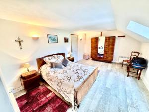 a bedroom with a bed and a cross on the wall at Maison d'Antan, Ambiance chevaleresque Cave voutée in Saint Laurent Nouan