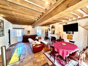 a large living room with a table and a tv at Maison d'Antan, Ambiance chevaleresque Cave voutée in Saint Laurent Nouan +69 photos