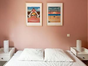 two pictures hanging on a wall above a bed at Grand écran, piscine, beach-volley, pétanque inclus in Cucq +19 photos