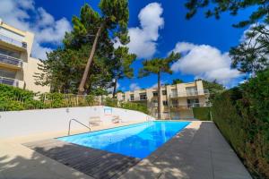 a swimming pool in front of a building at Grand écran, piscine, beach-volley, pétanque inclus in Cucq