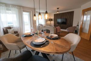 een woonkamer met een houten tafel en stoelen bij Wohnung im Rheintal in Küssaberg