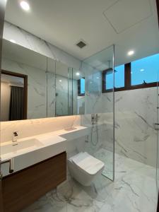 a bathroom with a toilet and a sink and a mirror at Zeus Living - Scandinavian Condo in Metropole in Ho Chi Minh City
