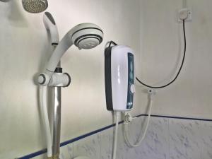 a shower head and a phone in a bathroom at SIlvas Surf Home in Weligama