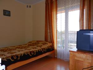 a bedroom with a bed and a window and a tv at Guest house Villa Leonardo in Herceg-Novi