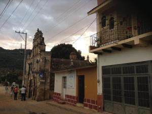 un grupo de personas caminando por una calle al lado de un edificio en Loft El Rosario, en Tlayacapan