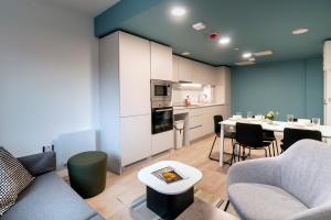 a living room with a kitchen and a table with chairs at Bradbury Place in Belfast