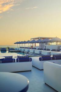 a row of lounge chairs and umbrellas on a beach at Radisson Beach Resort Palm Jumeirah in Dubai