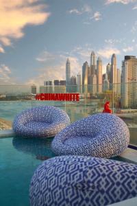 three bean bags on a ledge with a city skyline at Radisson Beach Resort Palm Jumeirah in Dubai