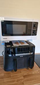 a microwave sitting on top of a toaster oven at Clovelly Green Cottage in Clovelly