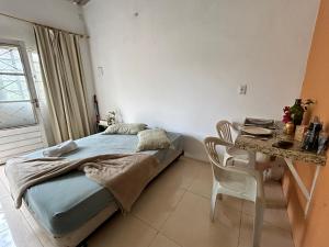 a small bedroom with a bed and a table at Caminito Brasília Apto 02 in Luziânia