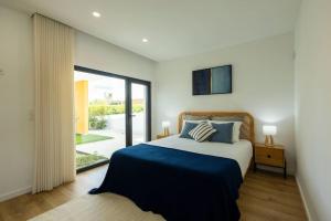 a bedroom with a bed and a large window at Villa Pessegueiros in Ericeira +54 photos