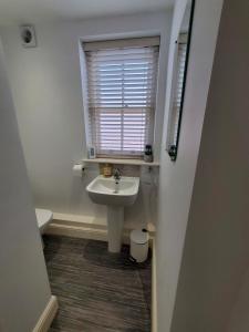 a white bathroom with a sink and a window at Ipswich Town Centre Apartment 8 in Ipswich