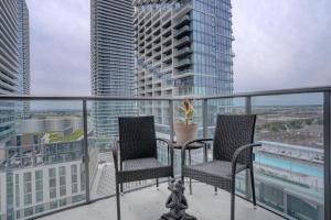two chairs on a balcony with a view of a city at Wonderland Apartment in Vaughan in Vaughan