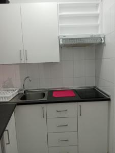 kuchnia z białymi szafkami i zlewem w obiekcie Monolocale w Puerto de la Cruz +1 zdjęcie