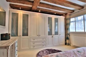 a bedroom with white cabinets and a bed in it at Tudor Cottage - hidden treasure in Tewkesbury