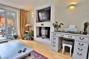a living room with a desk and a fireplace at Tudor Cottage - hidden treasure in Tewkesbury +5 photos