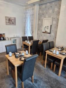 ein Esszimmer mit Tischen, Stühlen und einem Spiegel in der Unterkunft Rocklea Hotel in Blackpool