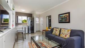 a living room with a couch and a glass table at Bay Lodge 29 in Ballito