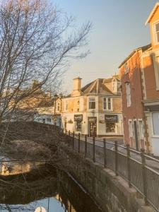 a bridge over a river in a city with buildings at WestLaigh Central Scotland with outdoor BBQ Hut, pets welcome in Strathaven