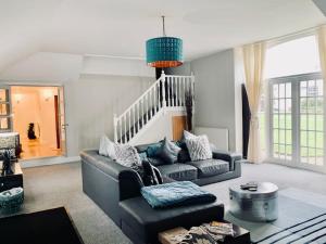 a living room with a couch and a table at WestLaigh Central Scotland with outdoor BBQ Hut, pets welcome in Strathaven