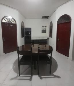 a room with a table and two red doors at Holiday Home, 3 Bedroom in Sungguminasa