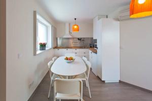 een keuken met een witte tafel en witte stoelen bij Matosinhos House Surf & Beach in Matosinhos