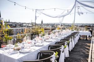 a long table with white tables and chairs on a roof at Pytloun Boutique Hotel Prague in Prague