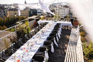 a long table with white tables and chairs on a balcony at Pytloun Boutique Hotel Prague in Prague