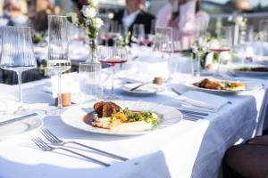 a table with plates of food and glasses of wine at Pytloun Boutique Hotel Prague in Prague