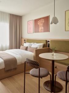 a bedroom with a bed and a table and chairs at Bob W Helsinki Kaarti in Helsinki