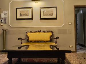 a yellow chair sitting under two pictures on a wall at Ca' Dell' Arte Luxury in Venice +96 photos