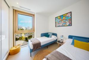 a bedroom with two beds and a large window at Intempo by Holuxe - 096 - 9th floor in Benidorm