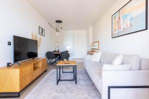 Una sala de estar con un sofá blanco y un televisor. en Intempo by Holuxe - 131 - 13th floor, en Benidorm