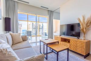Una sala de estar con un sofá y un televisor de pantalla plana. en Intempo by Holuxe - 131 - 13th floor, en Benidorm