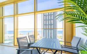 贝尼多姆Intempo by Holuxe - 022 - 2nd floor的有大窗户的房间里有一张桌子和几把椅子