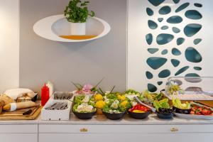 a counter topped with bowls of vegetables and fruits at Hotel Aqua Sopot - Destigo Hotels in Sopot