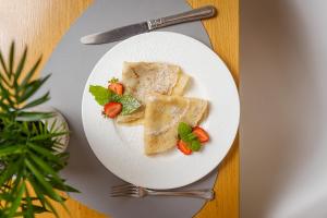 a plate of food with tofu and strawberries on a table at Hotel Aqua Sopot - Destigo Hotels in Sopot