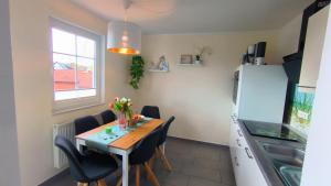 レリクにあるFerienwohnung OstseeStern Rerik mit Saunaのテーブルと椅子と冷蔵庫のあるキッチン +26枚の写真
