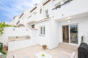 エステポナにあるE1 Desk Private patio Terrace Barbecueの白い建物を利用した白いアパートメントで、パティオが付いています。