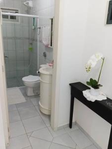 a bathroom with a toilet and a glass shower at Casa confortável com amplo espaço a 800 m da praia in Porto Belo