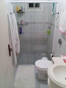 a bathroom with a shower and a toilet and a sink at Casa confortável com amplo espaço a 800 m da praia in Porto Belo +14 photos