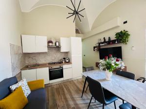 a kitchen and living room with a dining room table at Keope Urban Suite in Catania