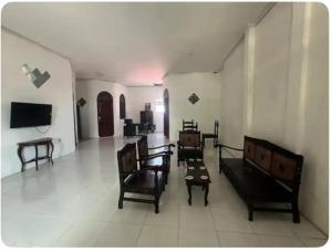 a living room with chairs and a tv on a wall at Holiday Home, 3 Bedroom in Sungguminasa