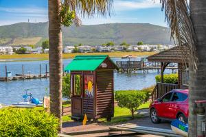 una pequeña choza al lado de un cuerpo de agua en Knysna - Sunrise Chalet, en Knysna