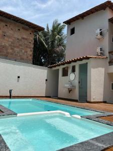a swimming pool in front of a house at Su House Suíte Arraial dAjuda in Porto Seguro +4 photos
