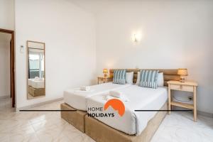 a bedroom with a large bed and a mirror at #245 Quinta do Julo by Home Holidays in Albufeira