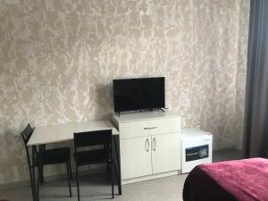 a bedroom with a desk with a tv on a wall at STAR MEN in Karagandy